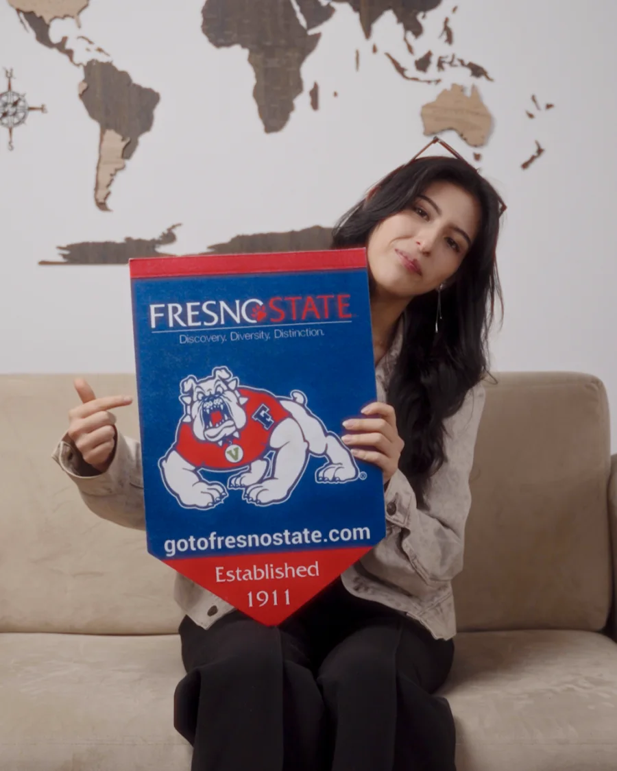 Estudiante AUP con el banderín de su universidad